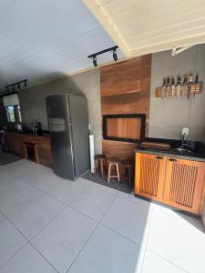 a kitchen with a stainless steel refrigerator and wooden cabinets at Casa Benedet's in Lauro Müller +24 photos