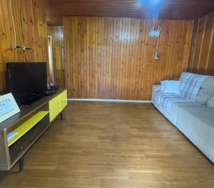a living room with a couch and a tv at Casa Benedet's in Lauro Müller