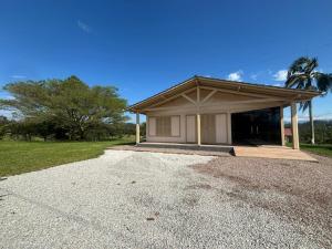 a small house with a roof on a gravel driveway at Casa Benedet's in Lauro Müller