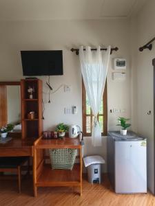 a room with a desk and a television and a table at Koh Mook The Home in Ko Muk