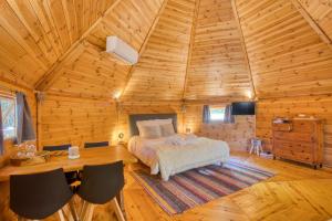 ein Schlafzimmer mit einem Bett in einer Holzhütte in der Unterkunft kota&bain nordique privatif-le bois de la pause- in Saint-Cybranet + 31 Fotos