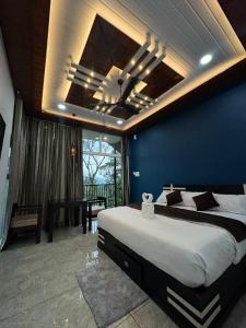 a bedroom with a large bed and a blue wall at Arvion Holidays in Vagamon