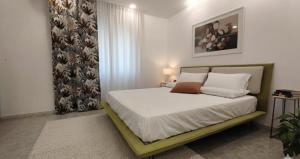 a bedroom with a bed with white sheets and pillows at La Ginestra Dell' Etna in Adrano