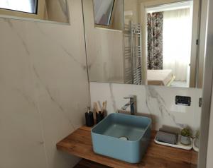 a bathroom with a blue sink and a mirror at La Ginestra Dell' Etna in Adrano
