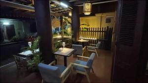 a restaurant with tables and chairs in a room at RainForest Guest Lodge in Luang Prabang