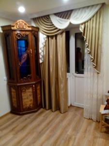 a living room with a grandfather clock and curtains at Джермук in Jermuk