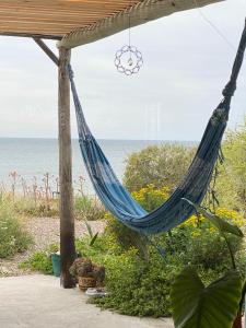 a hammock hanging from a pergola overlooking the ocean at La Celeste casa de playa in Las Grutas