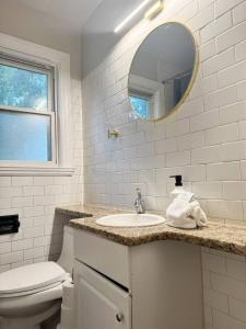 a bathroom with a sink and a toilet and a mirror at Spring Street Suites in Evansville