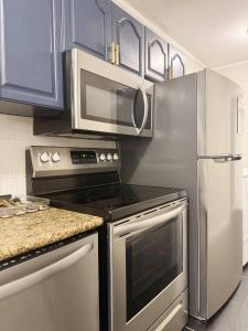 a kitchen with stainless steel appliances and blue cabinets at Spring Street Suites in Evansville
