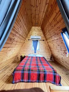 a bed in a wooden cabin with a window at Blue Bungalow Of Cyprus 