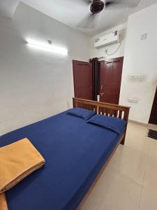 a bedroom with a blue bed in a room at Anugraha inn in Guruvāyūr