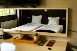 a mirror reflection of a bed in a hotel room at Hotel De Elderschans in Aardenburg