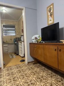 a living room with a flat screen tv on a dresser at Apartamento Fb in Água Boa
