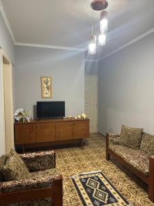 a living room with two couches and a flat screen tv at Apartamento Fb in Água Boa