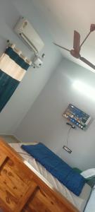 Cama en habitación con lámpara en la pared en MK Homestay, en Tiruvannāmalai