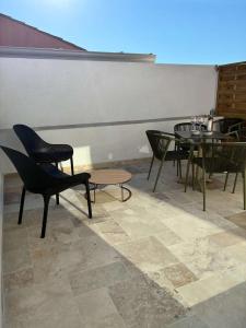 un gruppo di sedie e tavoli in una stanza di Villa Onyra - Cabane du midi - Appartement avec terrasse à 100m de la mer a Les Lecques