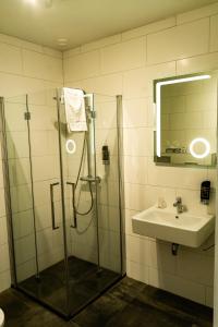 a bathroom with a shower and a sink and a mirror at Hotel De Elderschans in Aardenburg