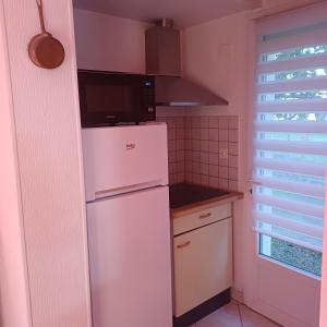 タルブにあるCharmante petite maisonの白い冷蔵庫と電子レンジのあるキッチン +3枚の写真