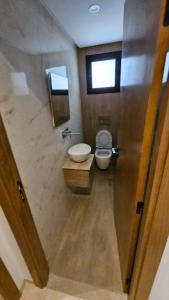 a bathroom with a toilet and a sink and a window at Résidence les Fatimides in El Aouina Station +5 photos