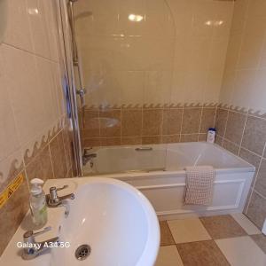 a bathroom with a sink and a bath tub at The Red Lion Heytesbury in Heytesbury