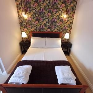 a bedroom with a bed with a floral wallpaper at The Red Lion Heytesbury in Heytesbury +5 photos
