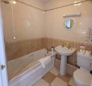 a bathroom with a tub and a sink and a toilet at The Red Lion Heytesbury in Heytesbury