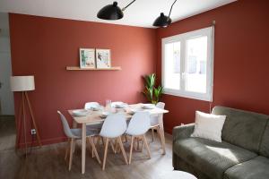 a dining room with a table and a couch at Charmant appartement T3 in Roussillon en Isere