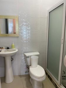 a white bathroom with a toilet and a sink at Habitación El Paredon in El Paredón Buena Vista
