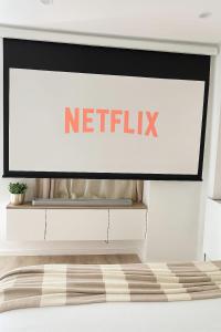 a netflix sign on a wall in a bedroom at Sauna Extérieur, Spa, Parking-L'Eden Suite in Lorient