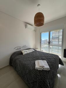 a bedroom with a bed with two towels on it at DEPARTAMENTO CENTRICO in Bahía Blanca