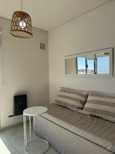 a white bedroom with a bed and a table at DEPARTAMENTO CENTRICO in Bahía Blanca