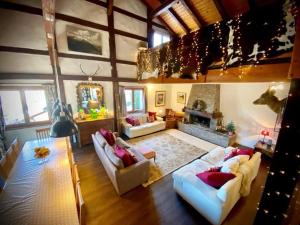 Una gran sala de estar con sofás y chimenea. en Alpine Chalet with Mountain Views, en Les Gets