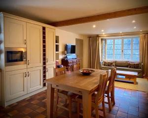 Una cocina y un comedor con mesa y sillas. en Alpine Chalet with Mountain Views, en Les Gets
