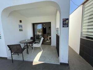 a balcony with a table and chairs and a kitchen at Corralejo Branded Residensed in Corralejo