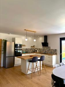 a kitchen with white cabinets and a table and chairs at Gîte des Peupliers in Courlay +12 photos