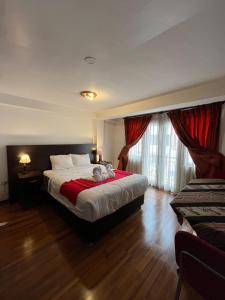 Un dormitorio con una cama grande con una manta roja. en La Estancia de la Abuela Cusco Hotel, en Cusco