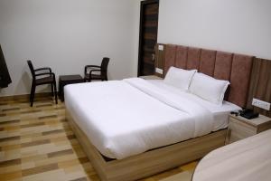 a bedroom with a large bed with a wooden headboard at Hotel Ram Janki Inn Ayodhya in Ayodhya