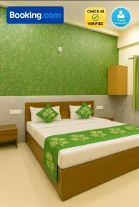 a bedroom with a bed with a green wall at HOTEL SoT PREMIUM in Agra +1 photo