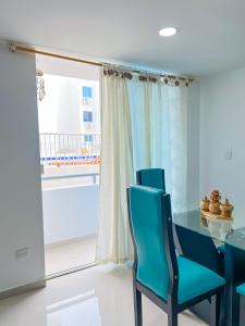 une salle à manger avec une table et des chaises bleues et une fenêtre dans l'établissement Celeste Caribe 101A, à Coveñas