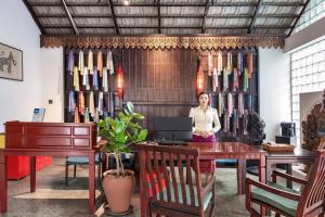 a woman sitting at a table with a laptop at Manyo Hotel and Resort in Luang Prabang +164 photos
