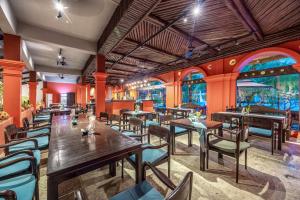 a restaurant with wooden tables and chairs and windows at Manyo Hotel and Resort in Luang Prabang