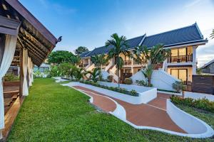 a courtyard of a house with a walkway at Manyo Hotel and Resort in Luang Prabang