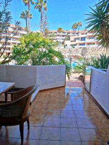 einen Balkon mit Tischen und Stühlen und Strandblick in der Unterkunft Appartamento Parque Albatros vista piscina e mare in San Miguel de Abona