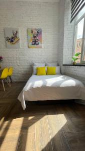 a bedroom with a large bed with yellow pillows at Квартира-студія в історичному центрі міста біля Центральної площі in Chernivtsi