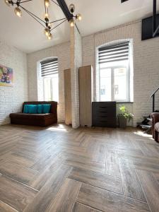a living room with a couch and wooden floors at Квартира-студія в історичному центрі міста біля Центральної площі in Chernivtsi