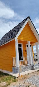 a small house with an orange at Roomstay Cheq Ayoh Pantai Penarik Setiu in Kampong Ru Sepuloh