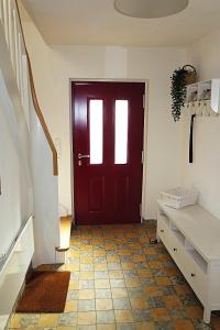a red door in a room with a tiled floor at Ferienwohnung Marlene 80 Qm in Ebersburg