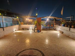 eine Terrasse in der Nacht mit einem Tisch und Lampen in der Unterkunft The moon Guest House in Jodhpur