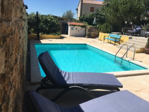 a swimming pool with two lounge chairs next to it at Holiday Home Ava1 with pool & Holiday Home Ava2 with whirlpool in Baderna