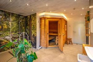 シールケにあるFerienanlage Zum Wildbach Schierkeの森の壁画が描かれたサウナ付きの浴室